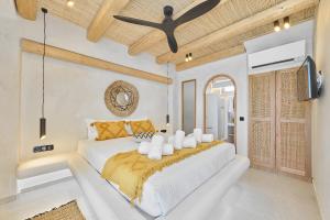 a bedroom with a large bed and a tv at Aegean Sunset Villas & Spa 'Villa Sun' in Skouloúfia +20 photos