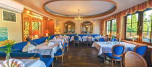 a restaurant with blue tables and chairs and windows at NaturMed Hotel am Park in Badenweiler