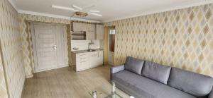 a living room with a couch and a kitchen at Reikartz City Kokand in Kokand
