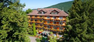 a large building in the middle of the trees at NaturMed Hotel am Park in Badenweiler