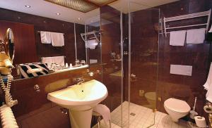 a bathroom with a sink and a toilet and a shower at NaturMed Hotel am Park in Badenweiler +33 photos