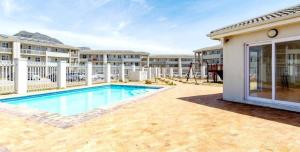 a swimming pool in front of a apartment building at Cozy corner apartment Muizenberg in Cape Town