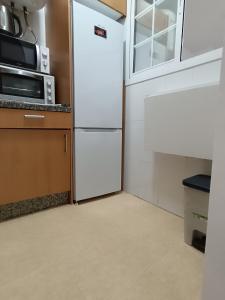 a kitchen with a white refrigerator and a microwave at Capuchinos House Apartment in City Center in Málaga +13 photos