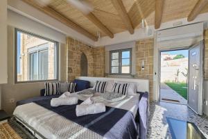 a bedroom with a large bed with pillows on it at Aegean Sunset Villas & Spa 'Villa Sky' in Skouloúfia +291 photos