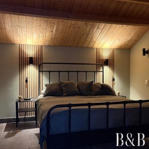 a bedroom with a large bed with a wooden ceiling at B & B In Two Hulten in Hulten