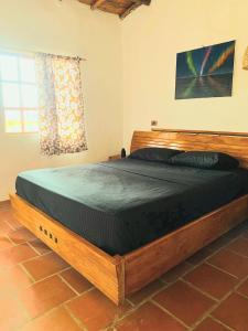a large wooden bed in a room with a window at Cabaña Umpalita para 4 cuatro personas in Los Santos