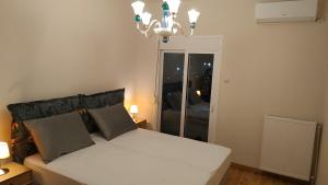 - une chambre avec un lit blanc et un lustre dans l'établissement Atelier Poly - Two Bedroom Apartment for 5 Persons -50m to Metro Sintrivani Station- 6th floor plain View - Center -, à Thessalonique