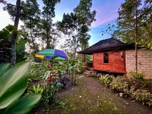 a house with a colorful umbrella in front of it at Green Escape in Tetebatu