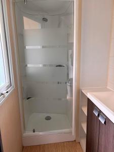 a glass shower in a bathroom with a sink at Le Camping de Ripan in Bessenay +28 photos