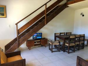 a living room with a dining room table and a staircase at Claro de Luna 2 in Villa Gesell
