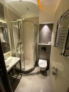 łazienka z prysznicem, toaletą i umywalką w obiekcie Aparthotel Łódź 55 Piotrkowska w Łodzi