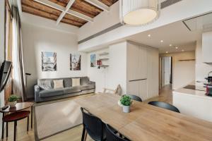 a dining room and living room with a table and chairs at Ola Living Boqueria in Barcelona