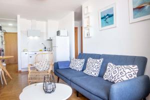a living room with a blue couch and a table at Mar de Fondo in Barbate
