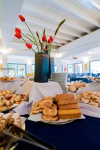 una mesa cubierta con platos de pan y bollería en Hotel Sierralago, en Villa Carlos Paz