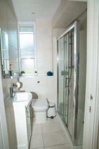 Un baño con inodoro, lavabo y ducha. en Seaview Apartments - 30 Marine Parade, Harwich - Perfect for business & long term stays, en Harwich