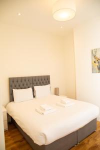 Un dormitorio con una cama grande con sábanas blancas. en Seaview Apartments - 30 Marine Parade, Harwich - Perfect for business & long term stays, en Harwich