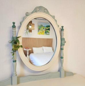 a bedroom with a bed in a round mirror at Sosodam Stay in Seoul