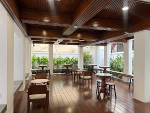 a restaurant with wooden ceilings and tables and chairs at VELA Korat Hotel & Cafe' in Nakhon Ratchasima