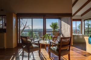a dining room with a table and chairs with a view at Forest Valley Cottages in Knysna
