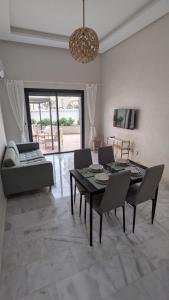 a living room with a table and chairs and a couch at Appt neuf Zenata- 2 chambres et Mezzanine - Piscine in Aïn Harrouda