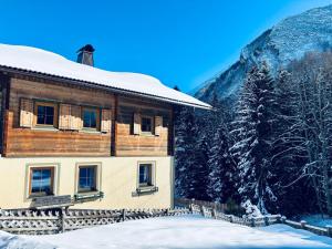a building covered in snow with a mountain in the background at Ferienhaus Marie in Tux