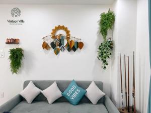 a couch in a living room with plants on the wall at VILLA 4BR DA NANG pool in Da Nang +34 photos