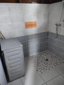 a bathroom with a shower with a tile floor at Bungalow An ka in Saint-Louis