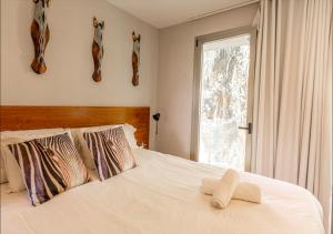 a bedroom with a white bed with a window at Casa Onix Ibiza in Ibiza Town +19 photos