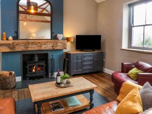 a living room with a fireplace and a television at Cedar Cottage in Barnard Castle