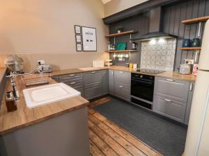 a kitchen with a sink and a stove at Cedar Cottage in Barnard Castle +24 photos