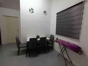 a dining room with a table and chairs and a window at Senja Kelabu Homestay in Kampong Bukit Tok Beng