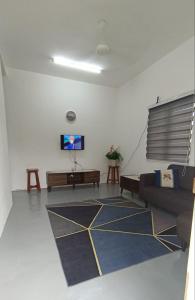 a living room with a couch and a flat screen tv at Senja Kelabu Homestay in Kampong Bukit Tok Beng