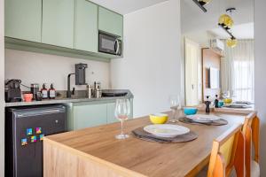 une cuisine avec une table en bois avec des verres à vin dessus dans l'établissement Bonaparte - 803 - Espetáculo - Recém Reformado - By Hospede Fácil, à Brasilia