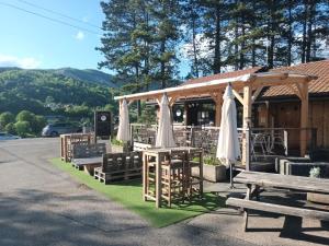 un pabellón con mesa, sillas, mesa y bancos en Wigwam et Dôdome sous les étoiles, en Champfromier