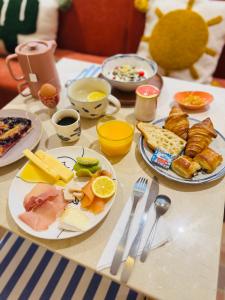 a table with plates of breakfast food on it at Hôtel Gabriel in Menton