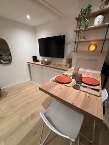 a dining room with a table with two chairs and a television at Appartement Ceyreste La Ciotat - jacuzzi in Ceyreste