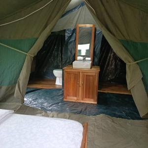 a bedroom with a bed and a mirror in a tent at MCF LUXURY Tents in Moshi
