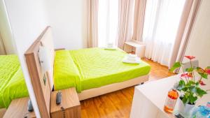 a bedroom with a green bed in a room at Hotel Bella Peschiera in Peschiera del Garda