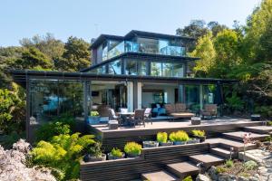 a house with glass walls and a patio at Lodge by the beach - Luxury, Beach access, Ocean views, Private chef in Kaiteriteri