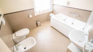 a white bathroom with a sink and a toilet at Hotel Bella Peschiera in Peschiera del Garda +12 photos
