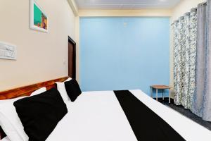 a bedroom with a bed and a large window at Hotel O Heaven Inn in Lucknow