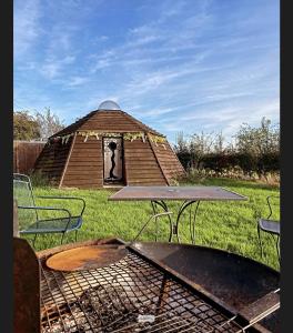 a picnic table and a grill in front of a gazebo at daisy meadow in Upton upon Severn