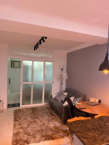 una sala de estar con un sofá y una mesa en Camboinhas - Piscina e Garagem na Rua da praia, en Niterói