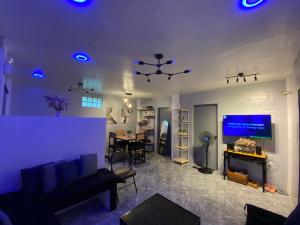 a living room with a couch and a tv and a table at Can accommodate up to 10 guest near Virac Airport in Virac