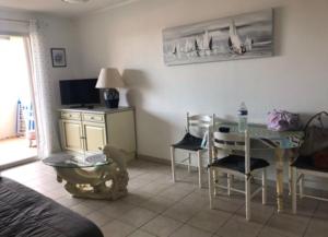 ヴァルラ・プラージュにあるAppartement Valras-plage 2chambres résidence avec piscineのテーブルとダイニングルームのあるリビングルーム