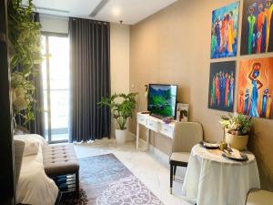 a living room with a desk and a tv in it at AQHOMES at Vinhomes Grand Park in Long Bình