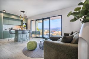a living room with a couch and a kitchen at Imola's Place - Sea-View & Pool in Slatine