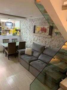 a living room with a couch and a table at Casa 23 em Condomínio à 700m da Praia dos Astúrias Guarujá - SP in Guarujá +23 photos