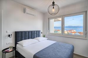 a bedroom with a bed and a large window at Imola's Place - Sea-View & Pool in Slatine