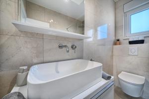 a bathroom with a white tub and a toilet at Imola's Place - Sea-View & Pool in Slatine +20 photos